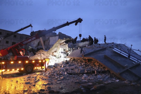 Civil defense teams attempt to rescue civilians trapped under the rubble after a powerful