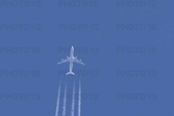 Airbus A340-300 jet aircraft of Lufthansa airlines in flight in a blue sky with vapour trails or