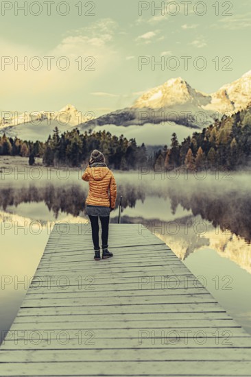 Young woman at Lake Staz near Sankt Moritz in the Engadine in Switzerland. Morning atmosphere with