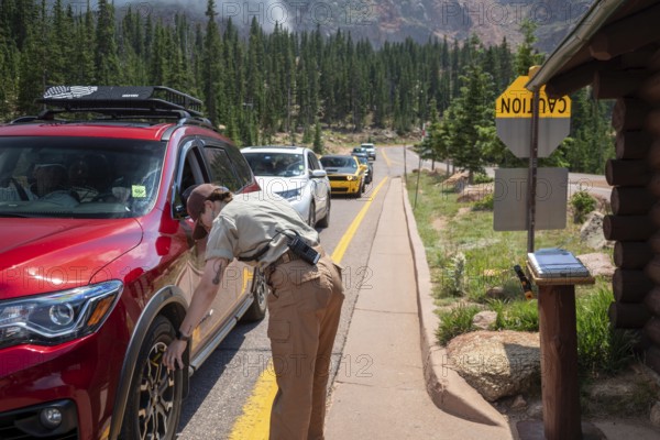 Colorado Springs, Colorado - A Pikes Peak ranger checks the temperature of brakes on a car