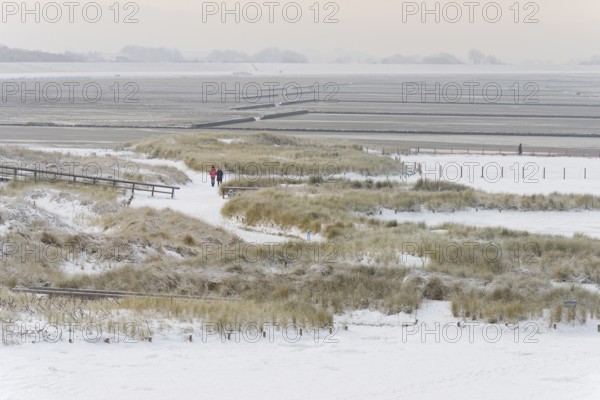 View over the snow-covered dune landscape of Norddeich, Wadden Sea at low tide, North Sea, Lower