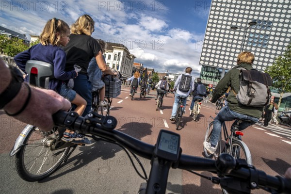 Ride your bike on the central cycle path on Lange Viestraat, Vredenburg, in the city centre of