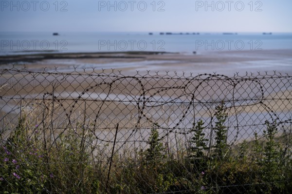 Barbed wire in front of Phoenix Caissons, caissons, concrete boxes, were used in the sea as