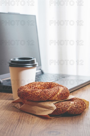 Simits with coffee on a wooden table, with a laptop, in a cozy working environment, snack,