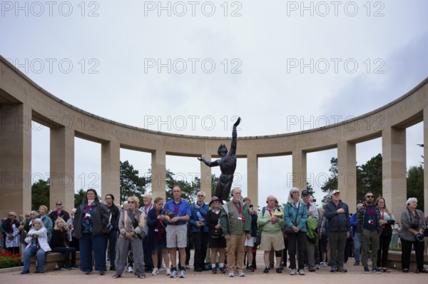 Funeral service, mourning relatives pause during the playing of the US national anthem, bronze