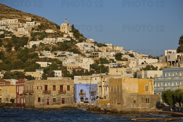 Coastal town with colourful houses along the water, church on the hill above the town, Agia Marina,