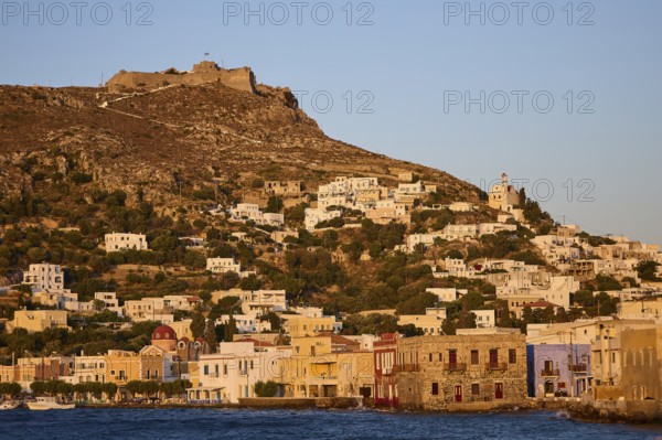 Panteli Fortress, Greek coastal village against a backdrop of hills at sunset, with traditional