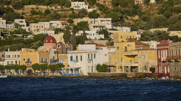 Colourful coastal houses with church in the background, located directly on the water, Agia Marina,