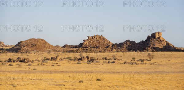 Barren landscape with hills of stacked rocks, desert landscape in the evening light at sunset,
