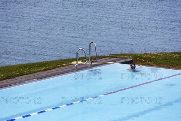 View from above of swimming pool by the sea, thermal bath, heated outdoor pool in Hofsos at the