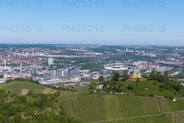 Vineyards and green hill with a building, city panorama in the background, view of the burial