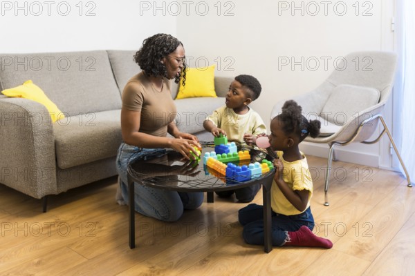 Mother, son and daughter enjoying quality time together, playing with colorful building blocks in