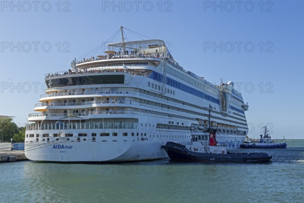 Cruise ship AIDA nova is pushed against the quay wall by tugboats, Warnow, Warnemünde, Rostock,