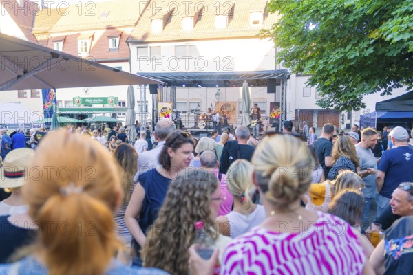 Spectators gather at a concert in the town centre, surrounded by a summery atmosphere, 950 years of
