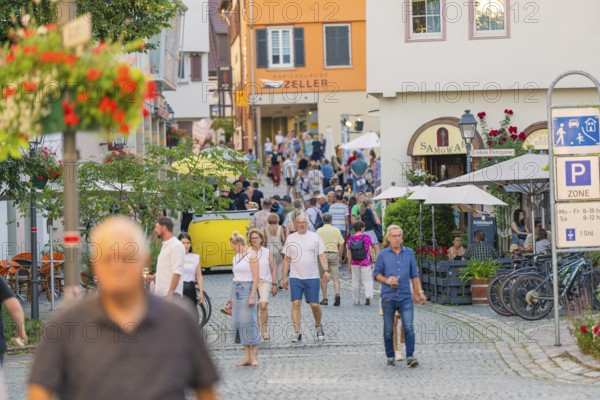 Cosy old town atmosphere with people strolling through a lively alley, 950 years of Weil der Stadt