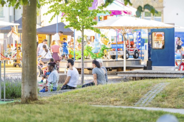 People enjoying a sunny day in the park with activities and carousel, 950 years Weil der Stadt