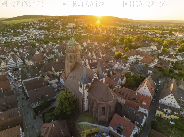 Aerial view of a church surrounded by an idyllic cityscape at sunset, 950 years Weil der Stadt