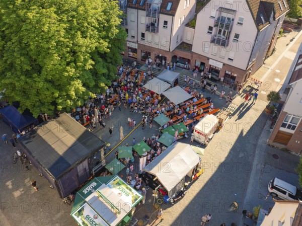 Large crowd at an open-air event, surrounded by buildings and trees, 950 years Weil der Stadt