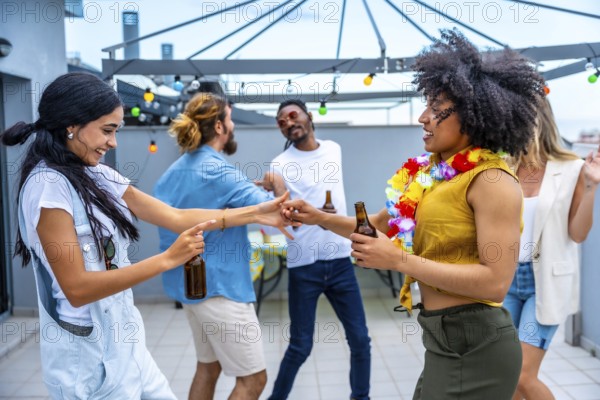 Cheerful young people enjoying drinks and dancing joyfully at a vibrant rooftop party, celebrating