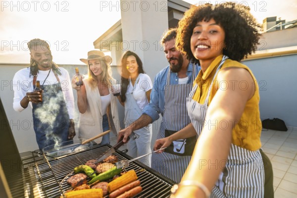 Cheerful friends grilling delicious meat and fresh vegetables while capturing selfies at a vibrant