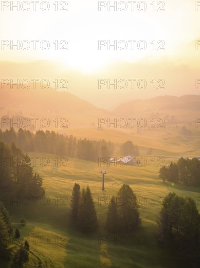 Forest and fog in the soft sunlight, illuminating the valley, Alpe di Siusi, Dolomites, South