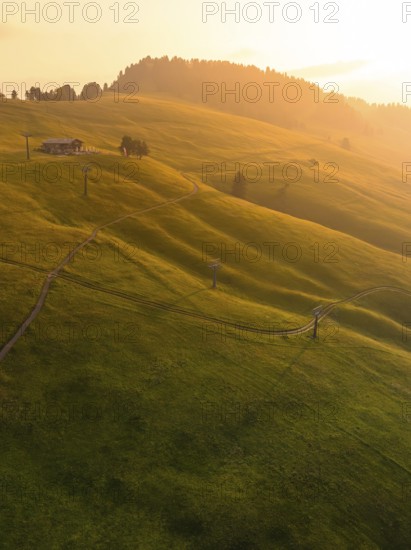 Wide meadow landscape in soft evening light with meandering paths, Alpe di Siusi, Dolomites, South