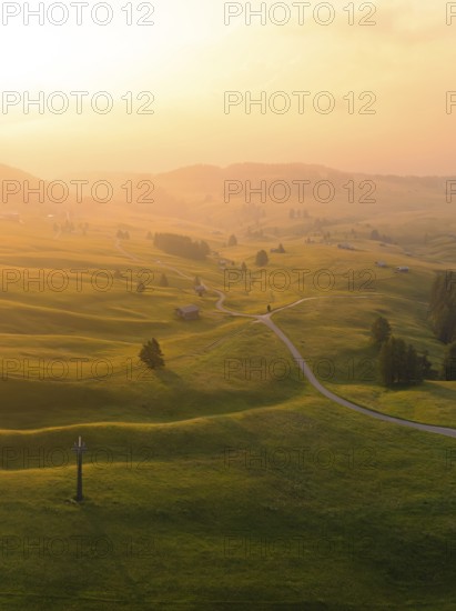 Hilly landscape at sunset with winding paths and warm light, Alpe di Siusi, Dolomites, South Tyrol,