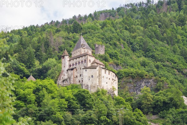 Historic castle complex on a wooded hill with defence towers and walls, Dolomites, South Tyrol,