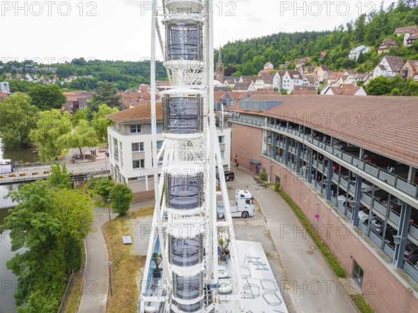 Narrow street view next to a high Ferris wheel in an urban environment, construction of a Ferris