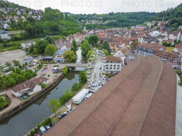 Aerial view of a town with a Ferris wheel in the centre, surrounded by densely built-up houses and