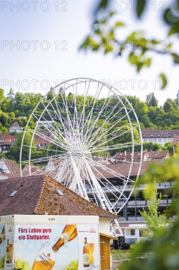 White Ferris wheel with buildings and advertising in the foreground, Ferris wheel construction for
