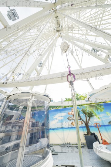 View upwards into the structure of a Ferris wheel with decorative background, Ferris wheel
