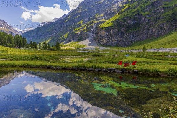 Mountains and clouds reflected in a pond, near Relais Tzoucdana, Zinal, Val d'Anniviers, Valais