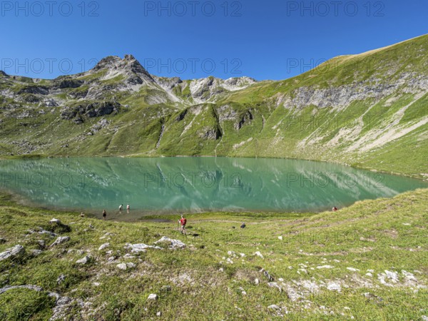 Hiker at lake Engeratsgundsee, mountain range between Oberstdorf and Bad Hindelang, Allgaeu,