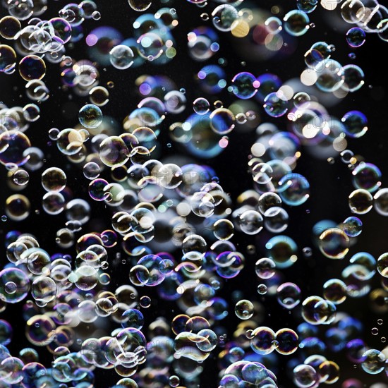 Many, small iridescent and floating soap bubbles against a black background, Recklinghausen, North