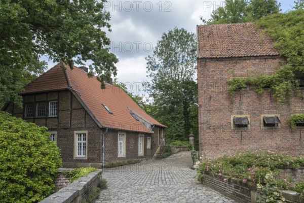 Idyllic rural scene with a half-timbered house and brick building under a cloudy sky, Haus