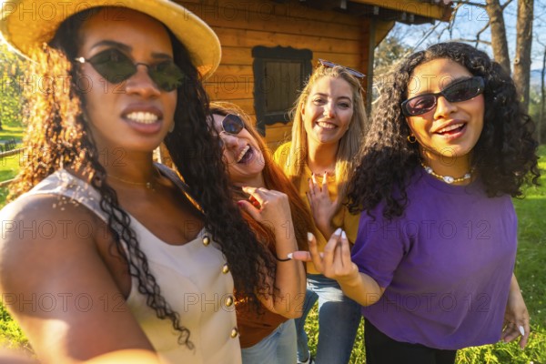 Four friends enjoying a sunny day in the countryside, capturing joyful moments together while