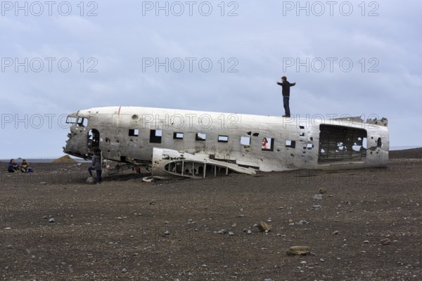 Tourist on aircraft wreckage, US Navy Douglas DC-3 transport plane, Sander, volcanic landscape,
