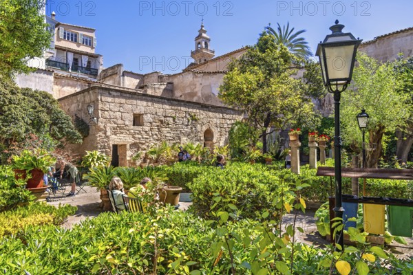 Lush green ornamental garden with visitors at the Arab Baths a historic site in city of Palma a