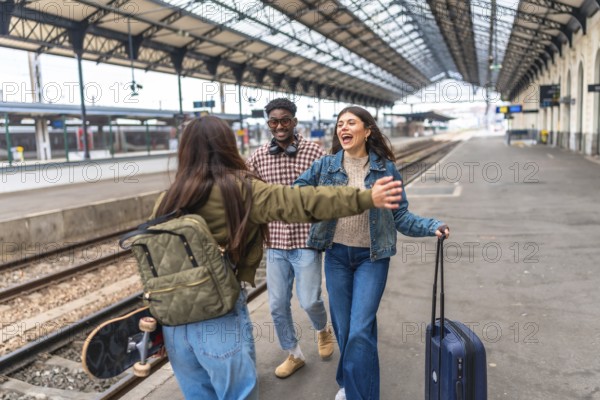 Happy multi ethnic friends meeting at train station, hugging each other, and starting their