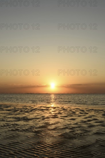 Sunset over the Wadden Sea on the German North Sea coast, low sun over Neuwerk, typical ripple