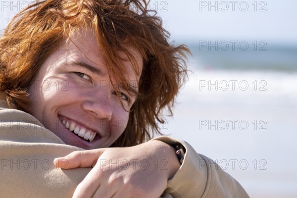 Young man with red hair, sitting on the beach, Jeffreys Bay near Port Elizabeth, Garden Route,