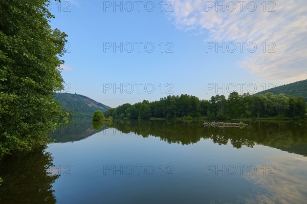 A clear blue sky with scattered clouds reflected on a quiet river, summer, Grünenwört, Wertheim,