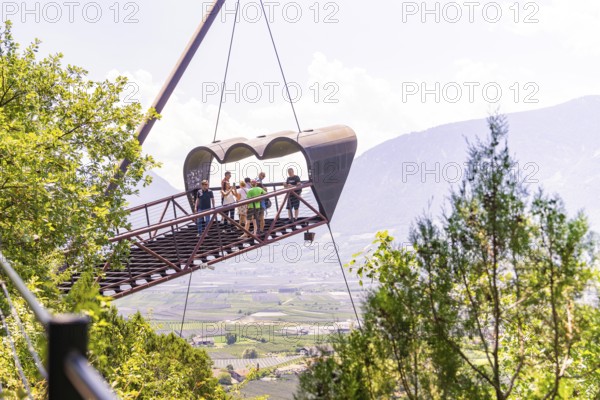Tourists on a floating viewing platform with a mountain landscape in the background, Botanical
