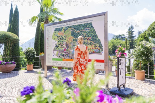 Woman in front of an information board in a sunny garden area, Botanical Garden, The Gardens of
