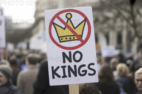 Close-up of protest sign with text No kings and crossed-out crown. Demonstration in progress.
