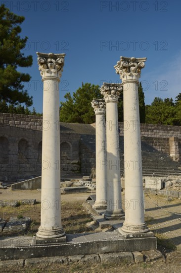 Three ancient columns in a historic landscape of ruins with clear sky, Temple of Apollo, Corinthian