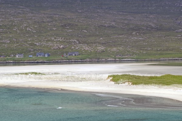 Tranquil coastal landscape with white sand and green land in flat light under a cloudy sky,