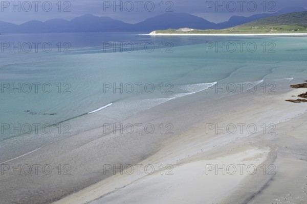 Wide, empty sandy beach with gentle waves, surrounded by mountains and a calm sea, Seilebost Beach,