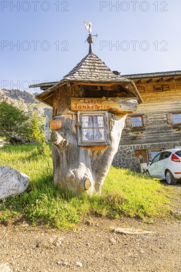 Whimsical wooden petrol station in a rural setting with car and meadow, Alpe di Siusi, Dolomites,